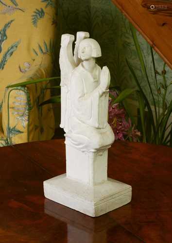 A plaster figure of a kneeling angel,