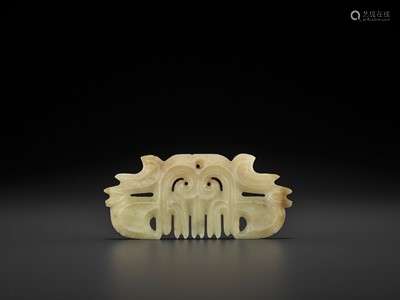 A CELADON JADE ‘TOOTHED’ PENDANT WITH MASK MOTIF