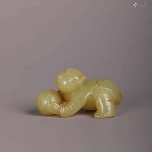 A Yellow Jade Carving Of A Child Playing Ball