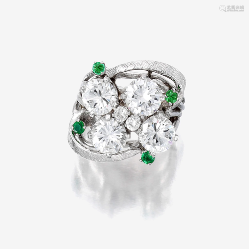 A diamond, green stone, and fourteen karat white gold