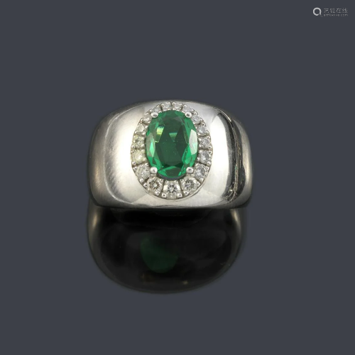 Ring with oval cut green glass with a border of