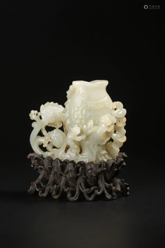 A white jade carving of 'Carp' vessel, surrounded with