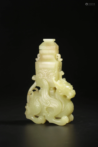 A yellow jade carving of a kylin carrying a vessel on