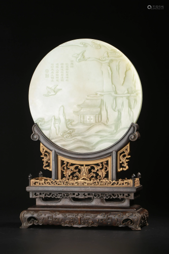 A Chinese carved round white jade plaque, on wood