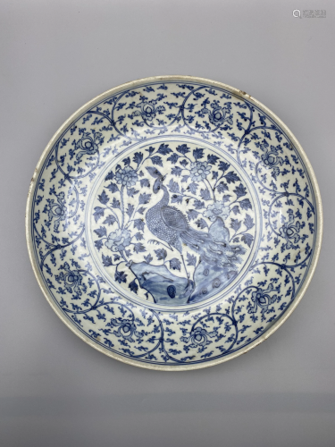 A blue and white charger, decorated with a phoenix,