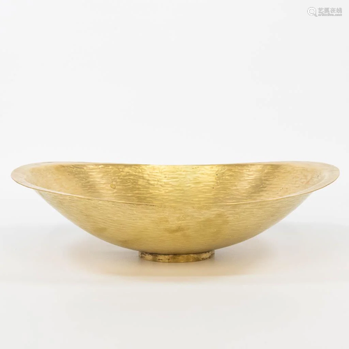 A bowl made of hammered copper and marked probably