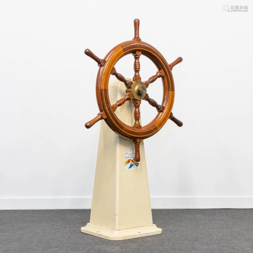 A vintage boat steering wheel, mounted on a metal