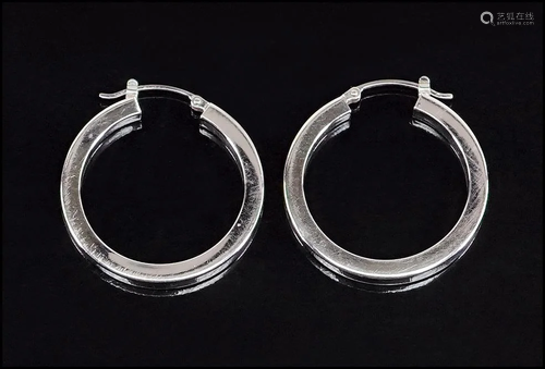 A Pair of 14 Karat White Gold Hoop Earrings.