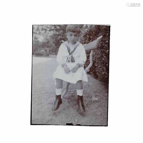 Photo seated boy on park bench in sailor suit