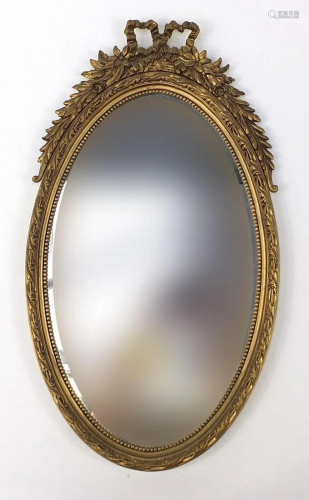 Ornate gilt framed wall mirror with bow crest, 72cm x