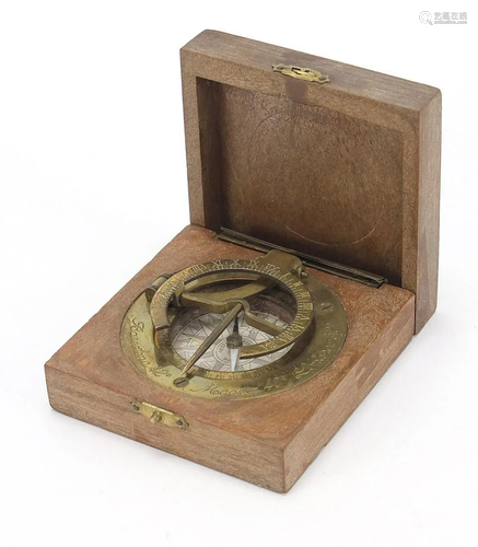 Brass pocket sundial housed in a wooden case carved