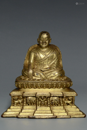 AN INSCRIBED QING GILT BRONZE FIGURE OF A LAMA