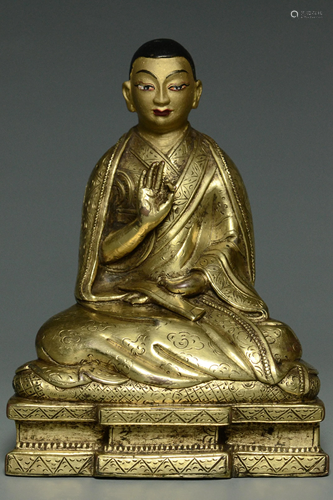 AN INSCRIBED QING GILT BRONZE FIGURE OF A LAMA