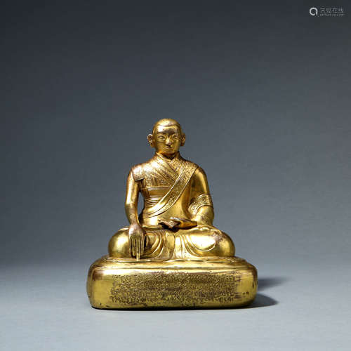 A GILT-BRONZE SEATED GURU