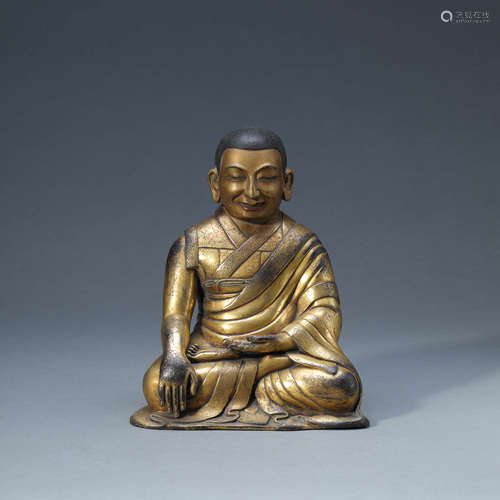 A GILT-BRONZE SEATED GURU