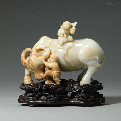 A CARVED WHITE JADE KID ON BUFFALO WITH WOODEN STAND