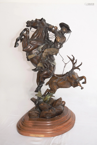 A Bronze Sculpture of a Cowboy on Prancing Horse with