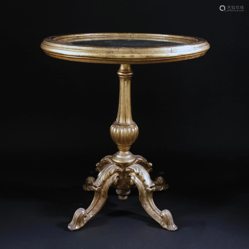 A gilt and carved wool table with round mirror top