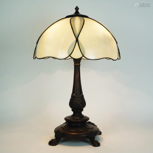 A patinated bronze table lamp with ivory glass