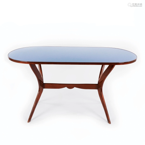 A walnut table with oval glass top with a turquoise