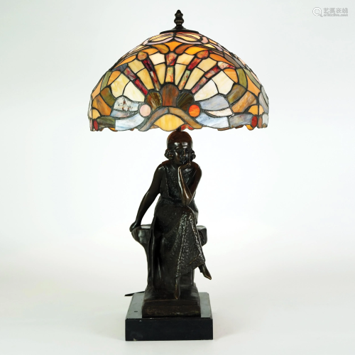 A patinated bronze table lamp with polychrome glass