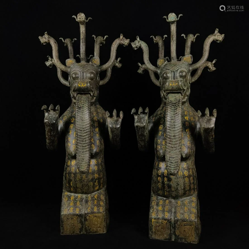 A pair of nine-headed beasts in bronze and gold in the