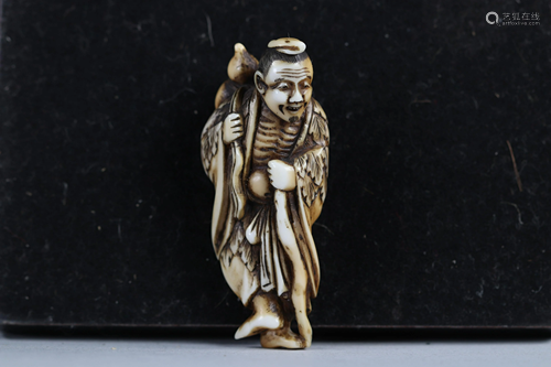 Netsuke / Okimono carved - a figure carrying a gourd.