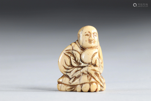 Netsuke carved - a figure holding a fruit, Japan Edo