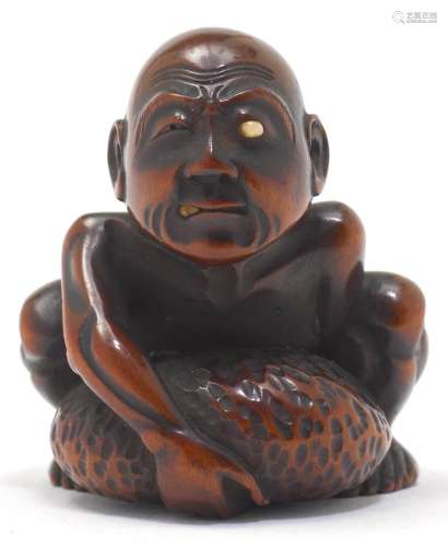 A NETSUKE OF A BLIND STONE LIFTER.