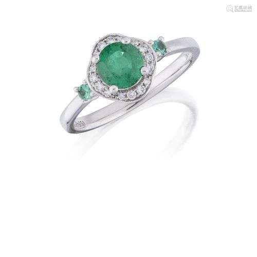 An emerald and diamond cluster ring, the circular emerald, w...
