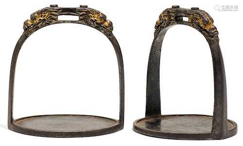 A PAIR OF PARCEL-GILT IRON STIRRUPS.