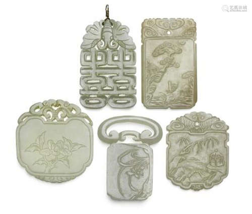 Four Chinese pendants of light green jade and belt buckle. W...