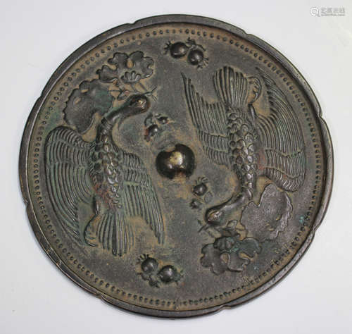 A Chinese bronze mirror of slightly lobed circular form, one...