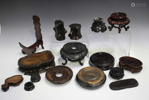 A collection of twenty-three mostly Chinese wood stands, lat...