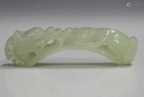 A Chinese white/pale celadon pendant, carved and pierced wit...