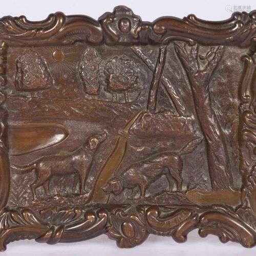 A bronze relief plaque depicting game hounds in a landscape,...