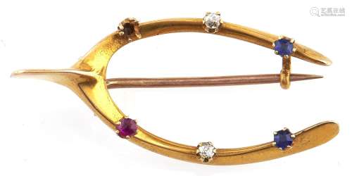 A ruby, sapphire and diamond wishbone brooch, in gold, one s...