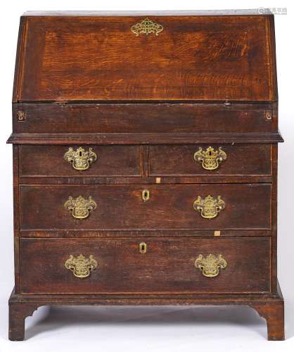 A George III oak bureau, with fitted interior, two short two...