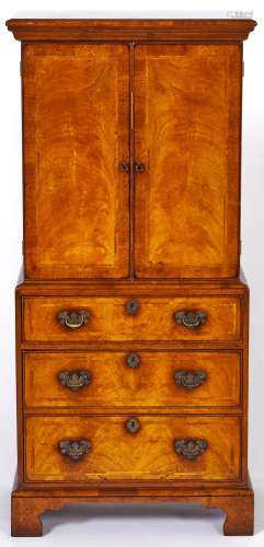 A walnut cabinet, 1980's, in George II style, enclosed by a ...