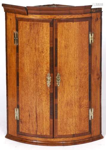 A George III inlaid oak bow fronted corner cupboard, 95cm h ...