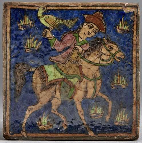 A Middle Eastern glazed tile, painted with a mounted falcone...