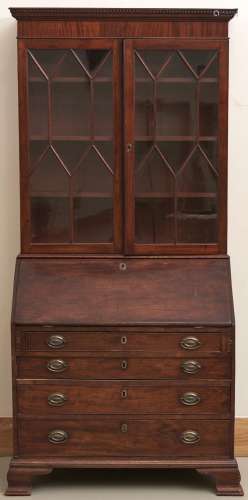 A George III mahogany bureau-bookcase, early 19th c, the bur...