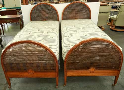 A pair of Edwardian arched and inlaid mahogany and caned sin...