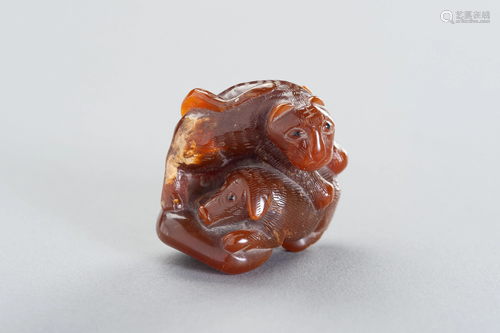 AN AMBER CARVING OF A TIGER AND DOG