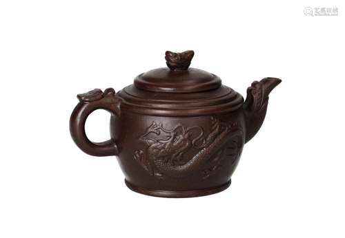 A Yixing teapot with a decoration in relief depicting a drag...