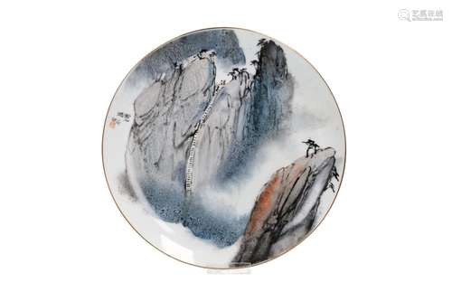 A polychrome porcelain plate with a mountainous river landsc...