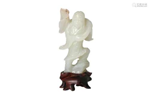 A jade sculpture of a priest with lotus flower, on wooden st...