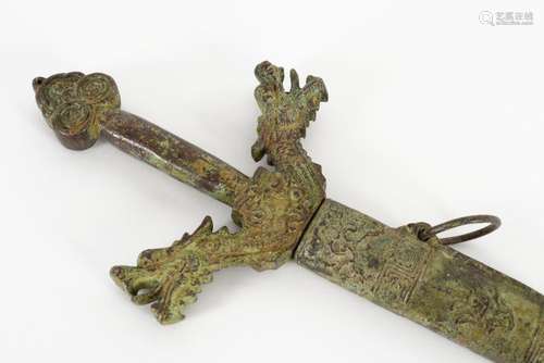 A bronze ceremonial sword with a grip in the shape of dragon...