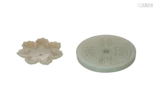 A green jade Bi-disc with carved decor of characters in zhua...