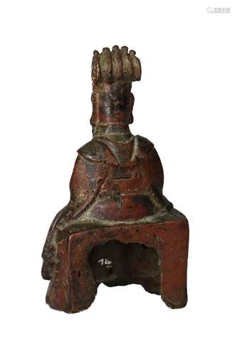 A bronze sculpture depicting a seated dignitary with folded ...